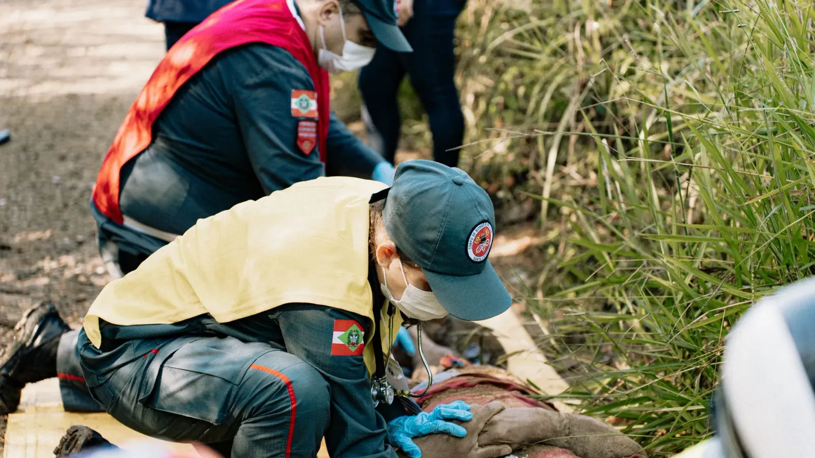 Imajen ida hatudu ema sira iha situasaun emergensia depois rai nakdoko, ho ekipa rescue halo servisu, iha uma ne'ebé monu tih