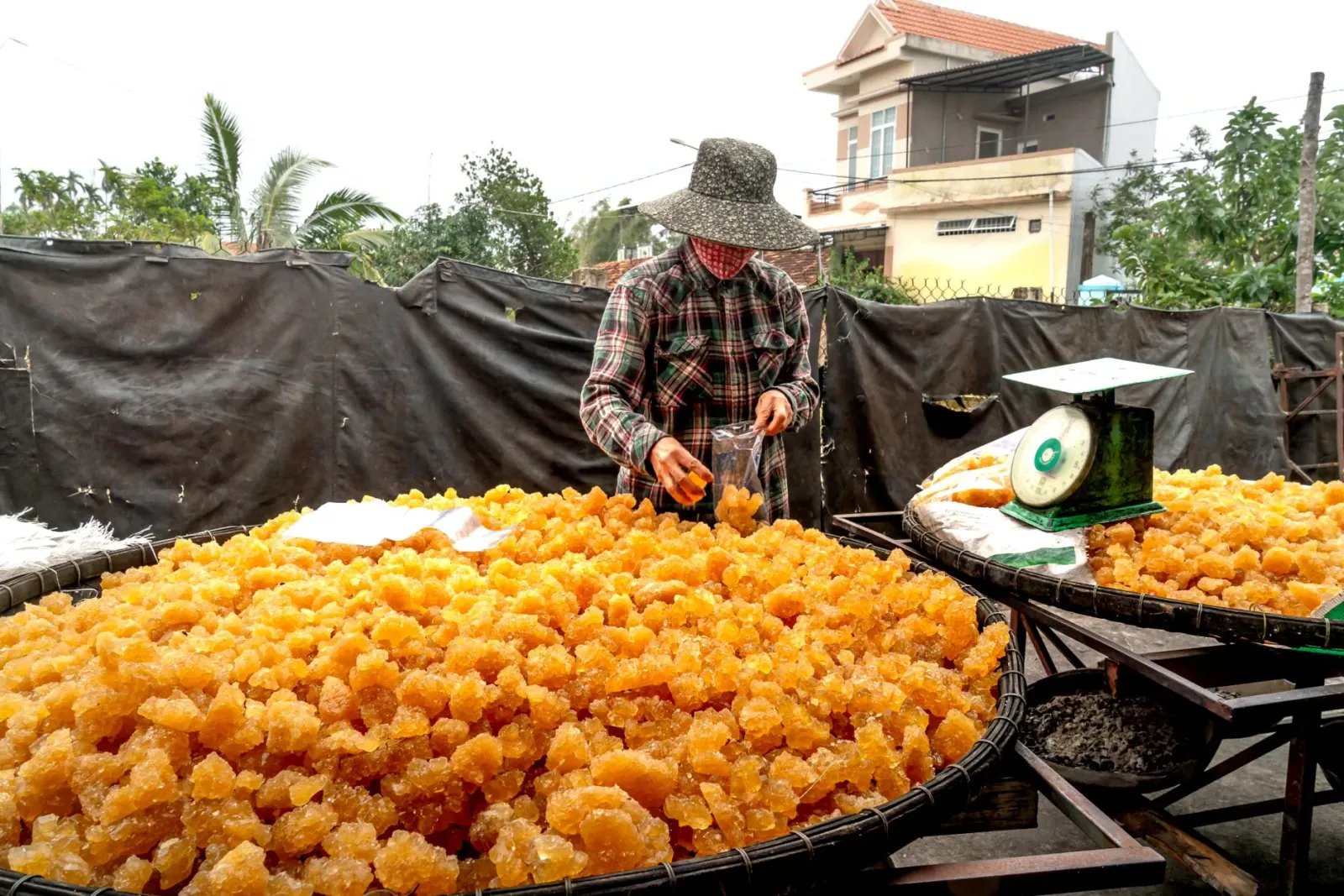 Ema iha Kerala halo jaggery iha fornu tradisionál, ho ai-fuan no fumaça, iha ambiente rural