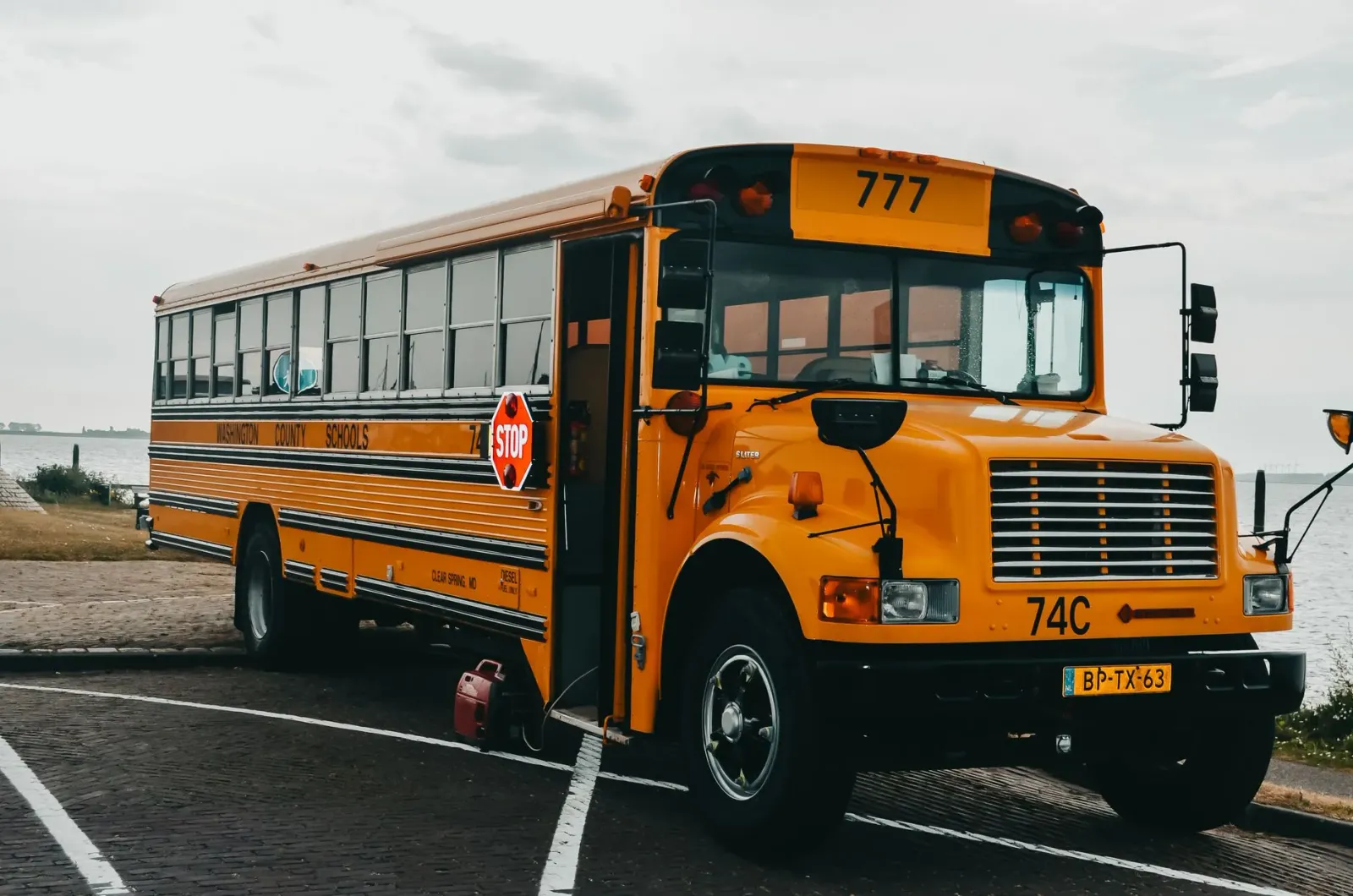 Elizabeth Banks hanesan Ms. Frizzle iha filme live-action Magic School Bus, ho nia vestidu karakterístiku no bus eskola iha k