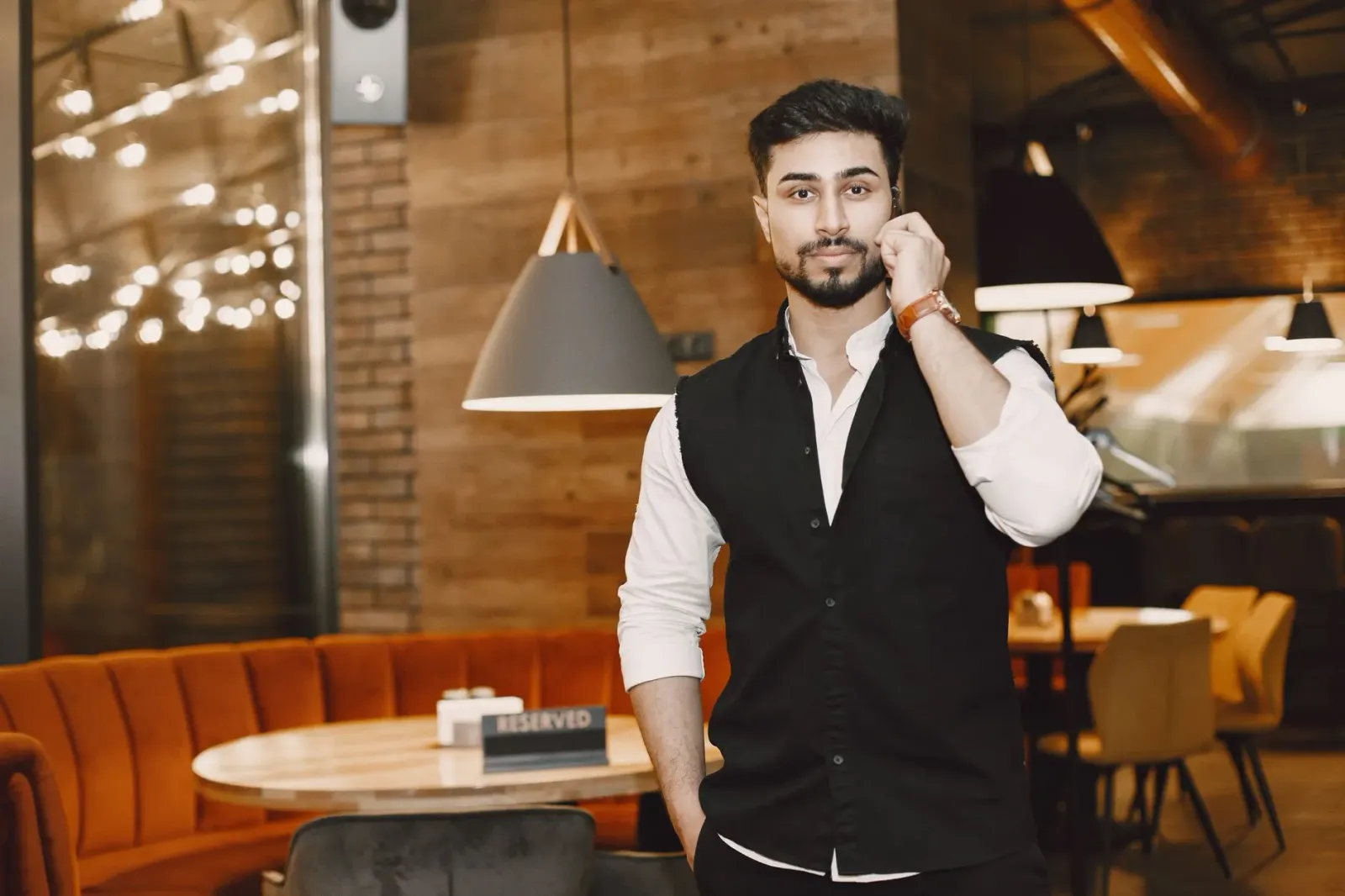 Ema ida utiliza smartphone hodi halo rezerva restoran liu husi asistenti AI ne'ebé iha ekrãn restoran iha kotuk