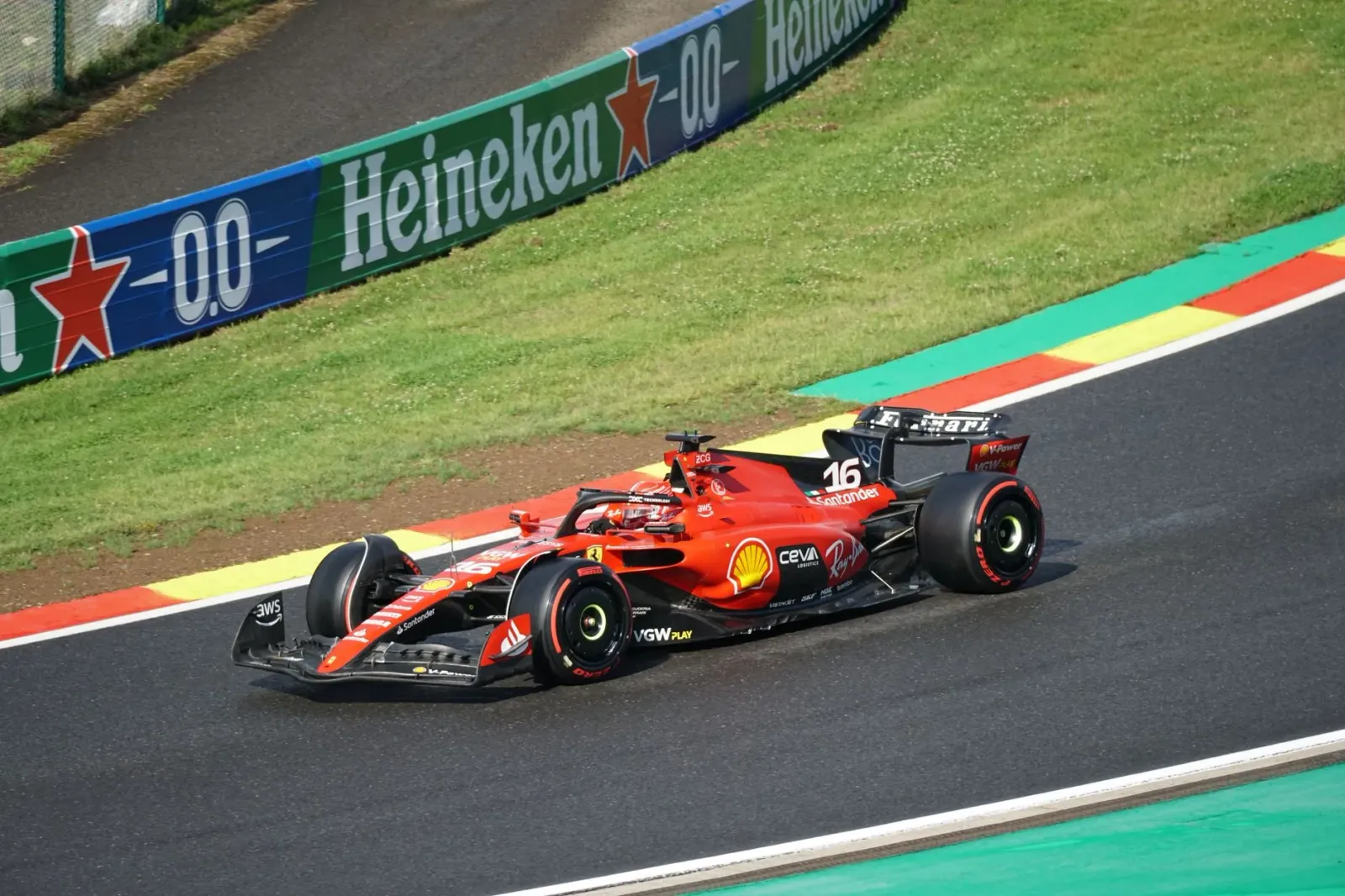 Imajen husi karru Ferrari F1 ne'ebé kompete iha ladeira, hatudu velosidade no risku ne'ebé atleta sira enfrenta.