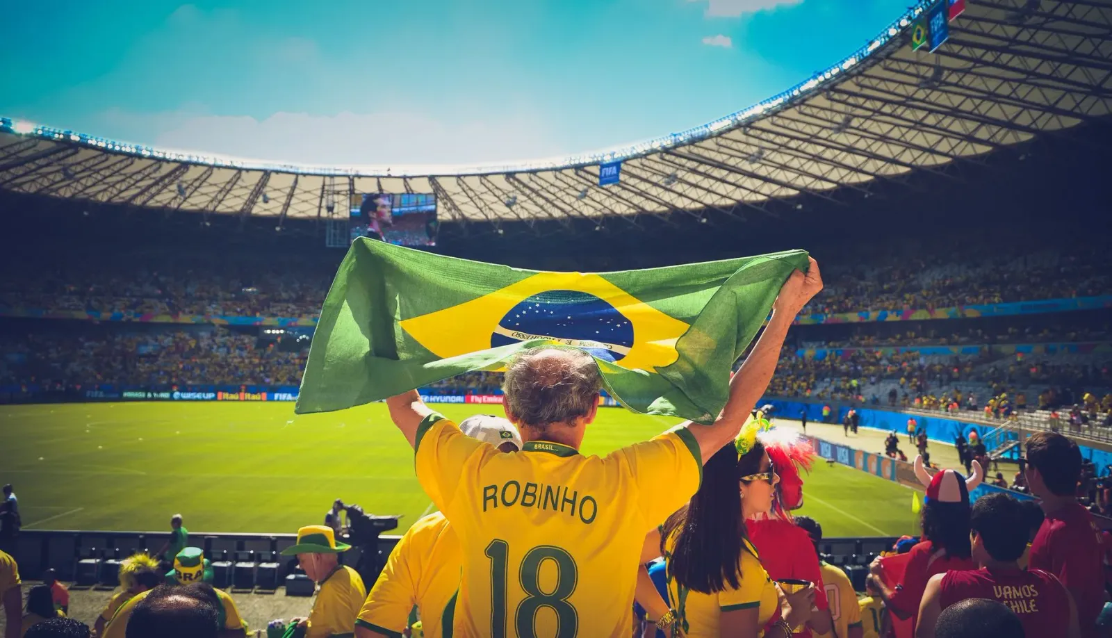 Imajen ne'ebé hatudu ema barak iha estádiu futebol, ho luz no animasaun durante FIFA World Cup 2026, hanesan exemplu eventu e
