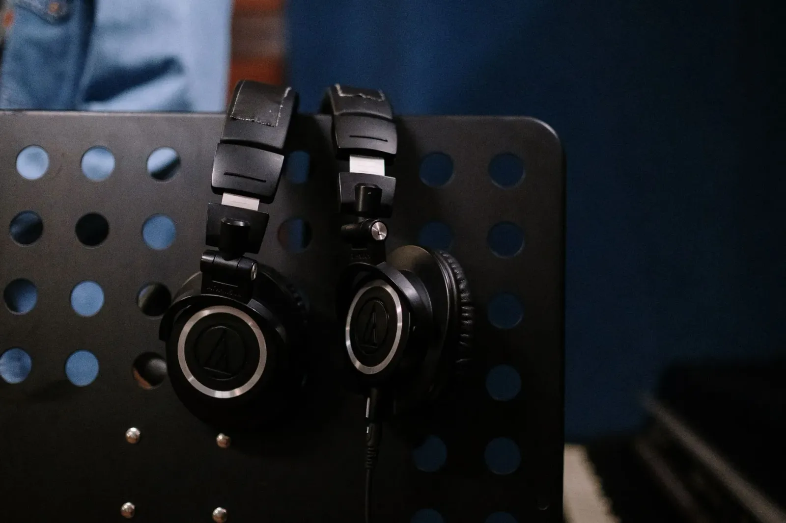 Pesoál ida uza headphone iha estúdiu músika ho ekipamentu áudio modernu hanesan DAC no amplificador, simboliza uniaun entre t