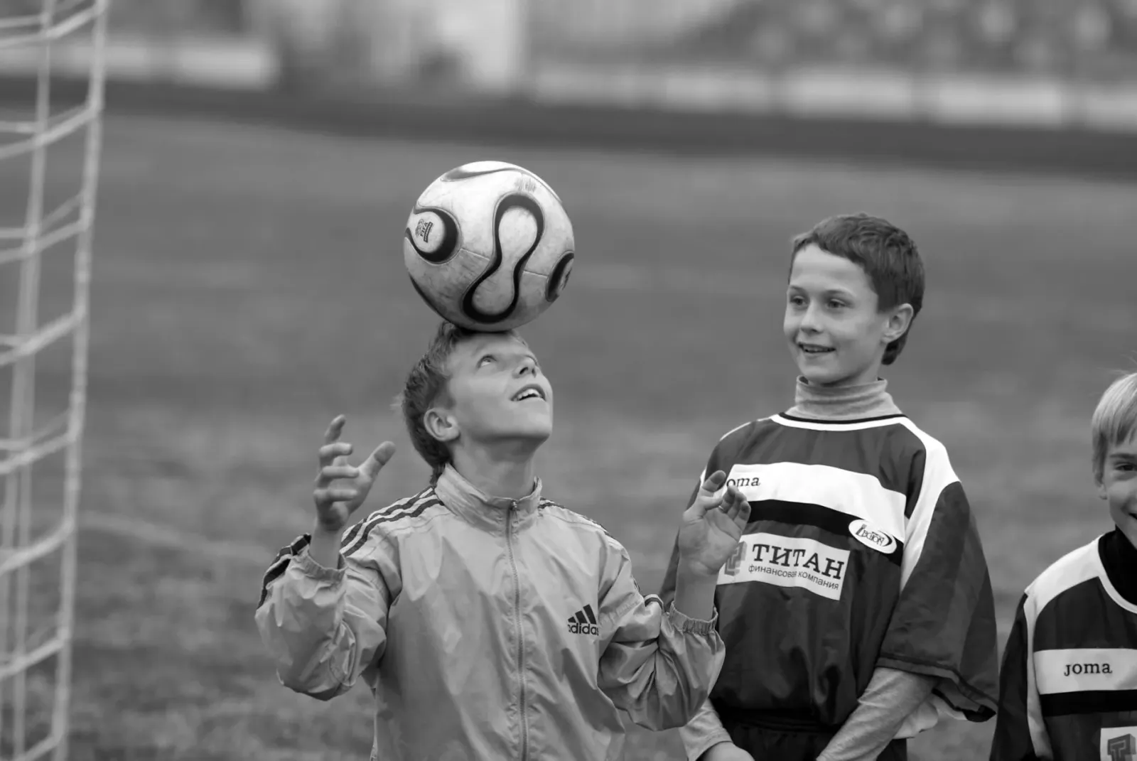 Imajen ida ne'ebé hatudu jogadór futebol nia ulun tuka bola no iha sorin seluk imajen labarik sira iha protestu besik eskola 