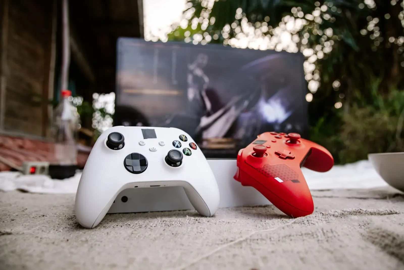 Imajen ida hatudu palco konferénsia Microsoft Build 2026 ho projetor boot no Valve Steam Controller iha mesa iha oin, hanesan