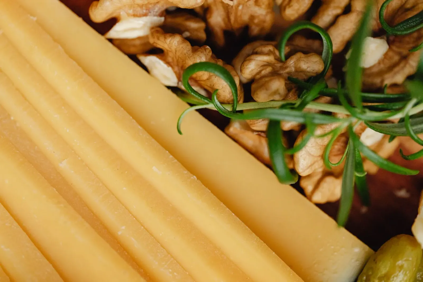 Imajen hatudu snack saudável hanesan cheese sticks, nozes, no iogurte grego iha mesa, ne'ebé di'ak ba ema ho fígado bokur.