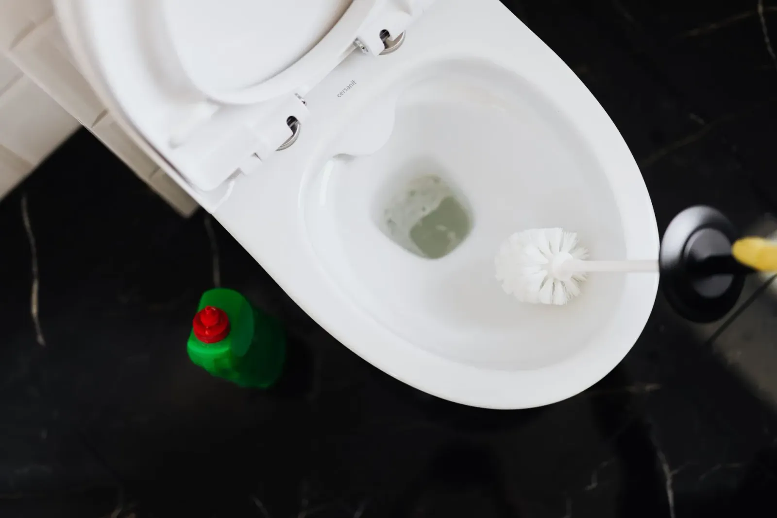 Ema ida hamaus lixívia iha balde atu uza ba sanitizasaun tangke bee RV, ho RV iha kotuk