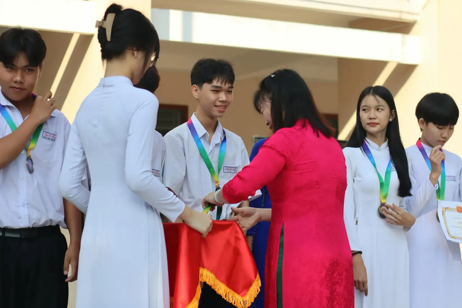 Estudante ida iha serimonia Emmy simu bolsa estudu ho sorriso, iha kotuk ema barak haree ho orgullu