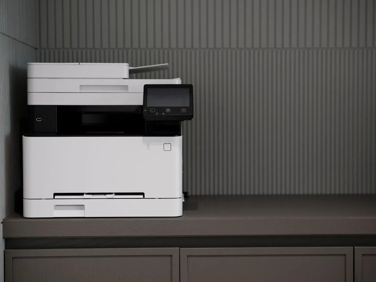 Imajen ida hatudu printer foun SHARP iha ambiente eskritóriu modernu, ho komputadór no dokumentu sira