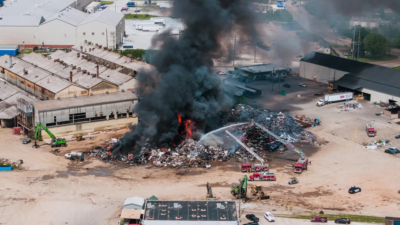 Asu nabilan boot husi fogo iha scrapyard Milwaukee, sinal laranja no fumo nakonu iha lalehan, besik uma sira