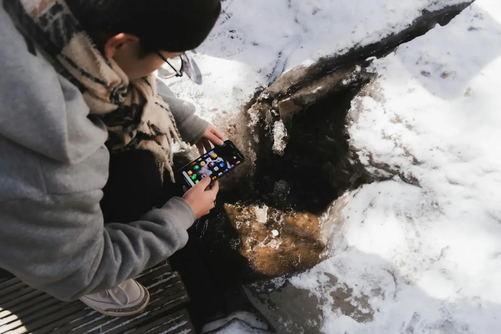 Ema ida uza smartphone ho aplikasaun saúde iha fatin besik drein bee poluitu, hatudu kontraste entre teknolojia no ambiente t