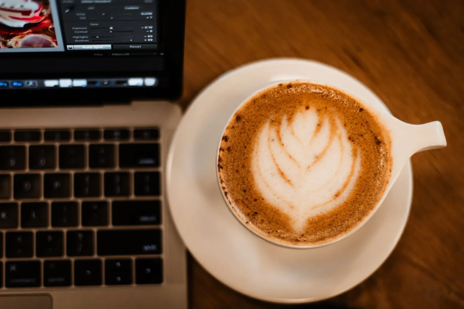 Imajen ida husi kafé virtual iha jogu Coffee Talk Tokyo, ho meja aihamar no xikra kafé, ne'ebé hatudu ambiente konfortável no