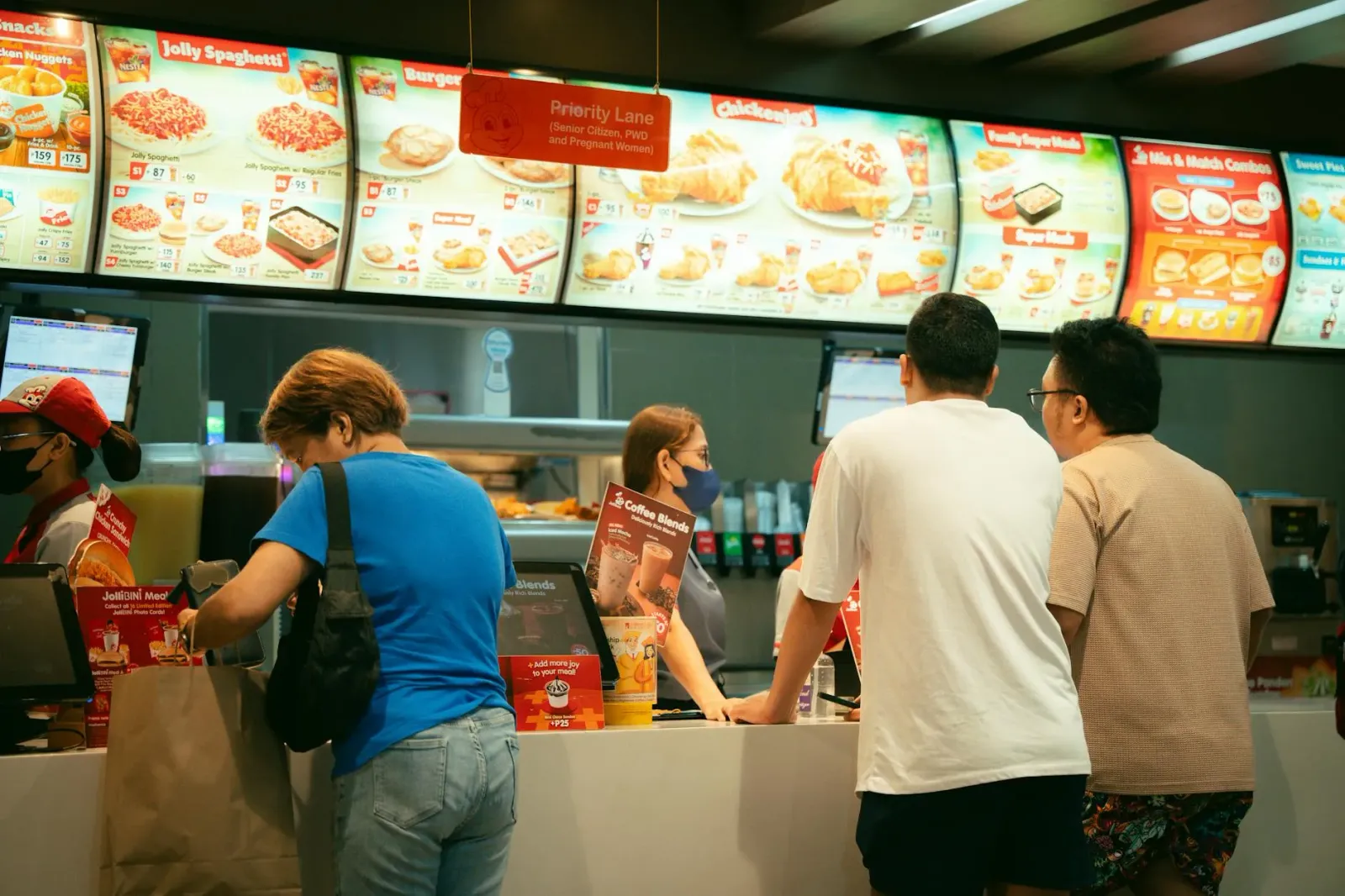Imajen ida hatudu restoran Jollibee iha Hong Kong ho neon boot, hanesan símbolu ba estratéjia negósiu global ne'ebé adapta ba