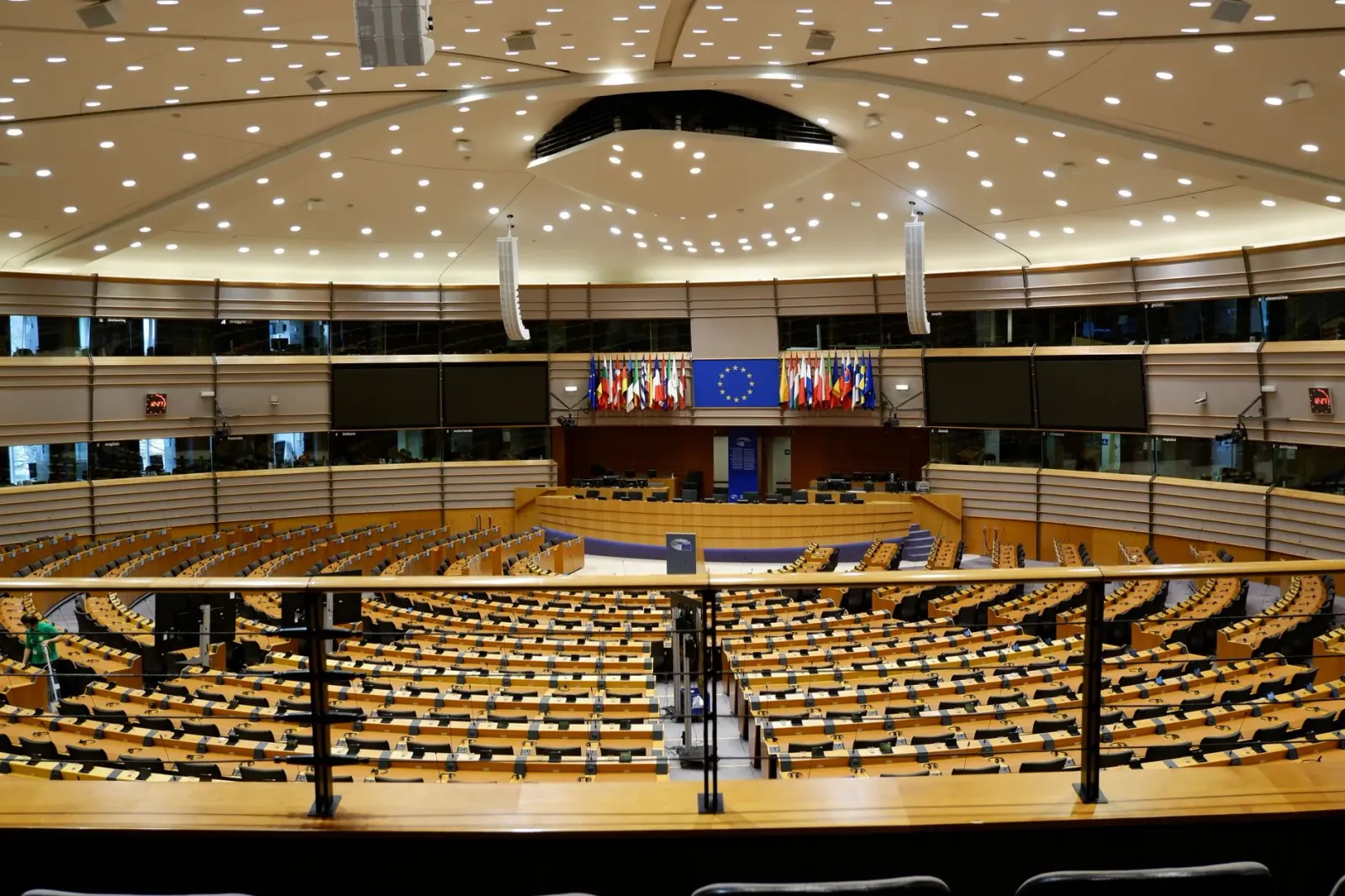 Imajen ida hatudu enkontru kona-ba regulamentu inteligénsia artifisiál iha Uniaun Europeia, ho banner sira ne'ebé hakerek 'AI