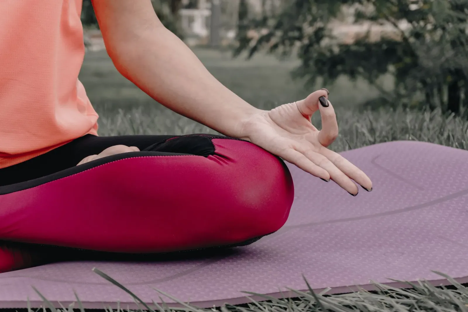 Ema ida tuur hela iha natureza verde, hanehan matan, medita ho atmosfera kalmadu. Imajen ne'e ilustra saúde laran no meditasa