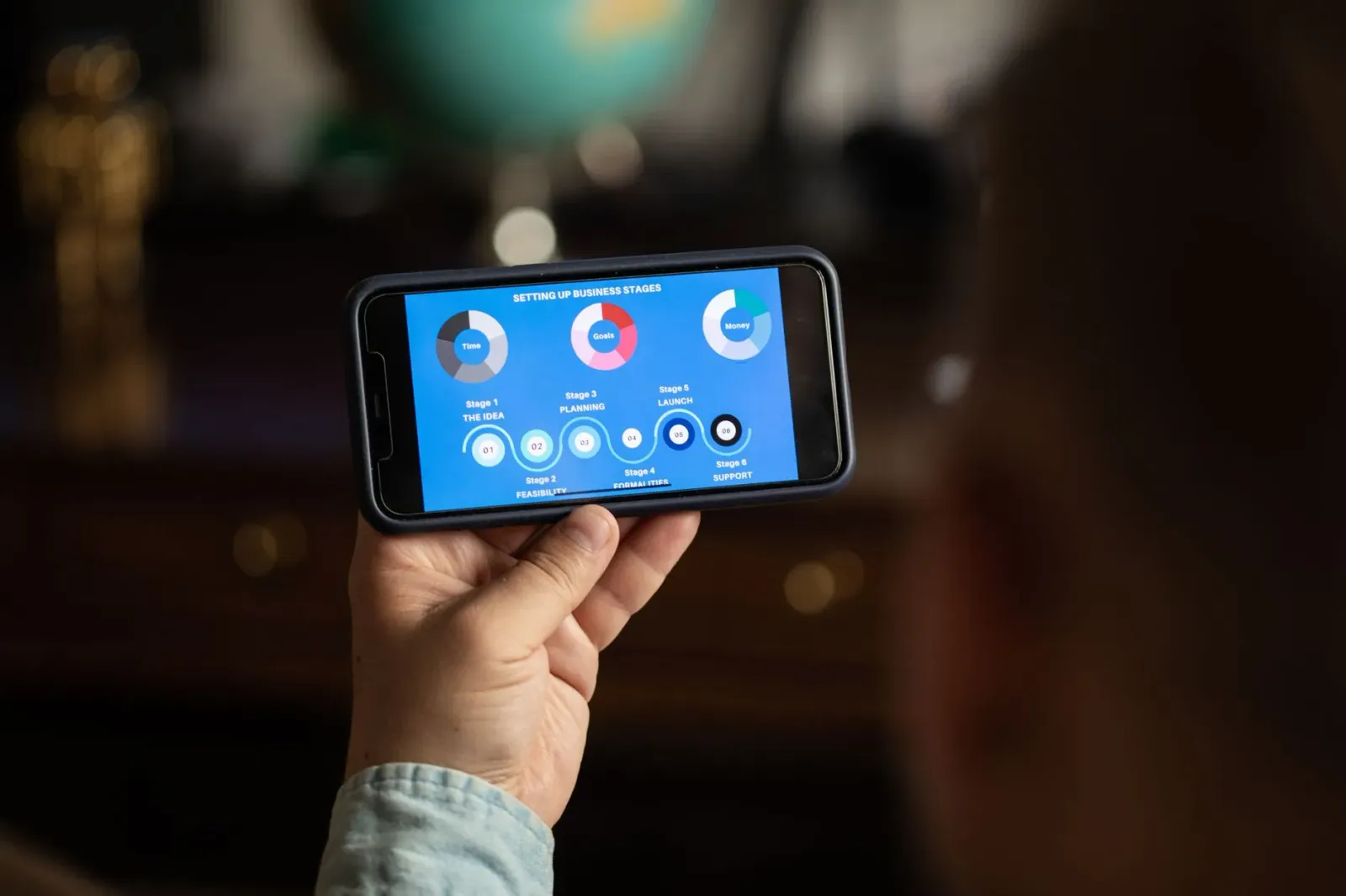 Andrew Yang hatudu smartphone iha eventu negósiu, hanesan ezemplu husi nia estratéjia foun iha setór telefone móvel