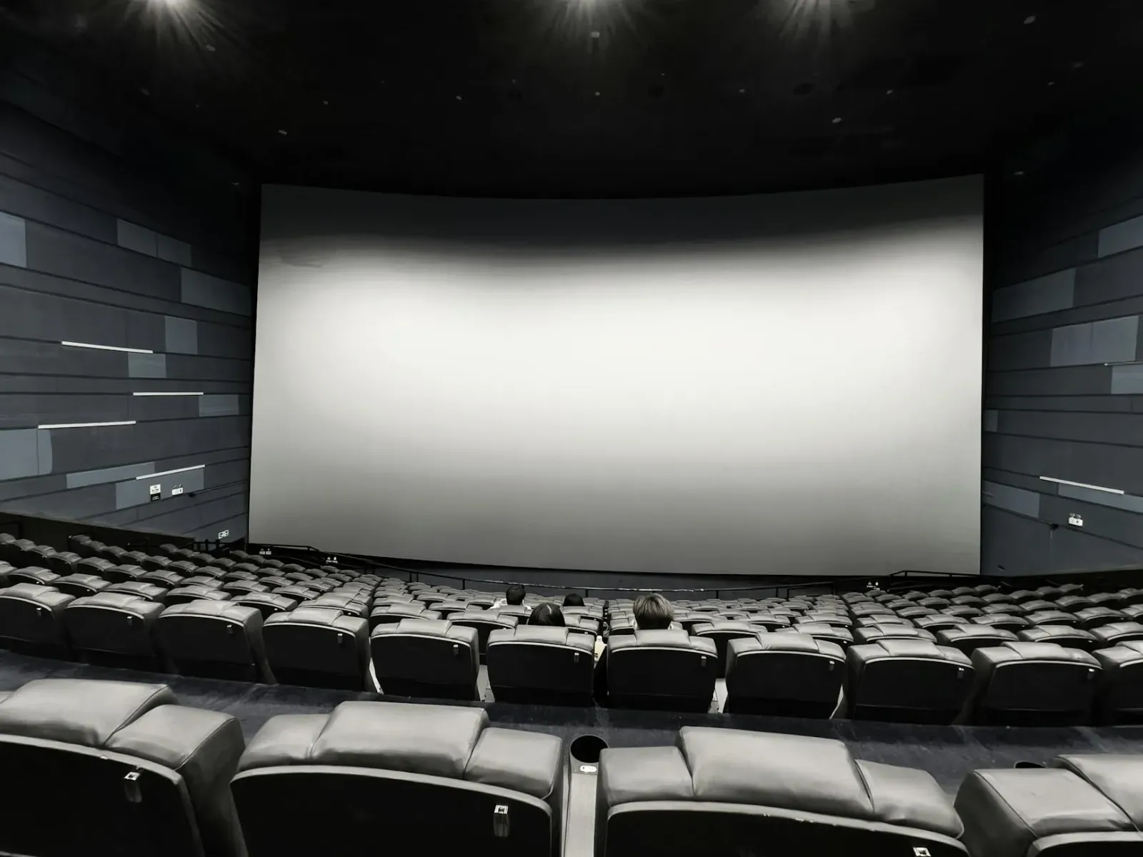 Imajen ida husi sala IMAX ho tela boot no kadeira mamuk, hatudu esperiénsia sinemátika ne'ebé imensivu