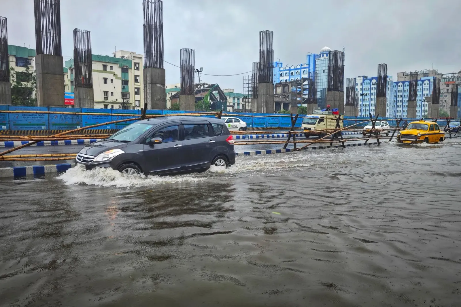 Imajen hatudu bee boot tama ba área uma luhan iha Juhu, Mumbai, durante udan forte, ho edifísio grande no ai-hun molik, hanes