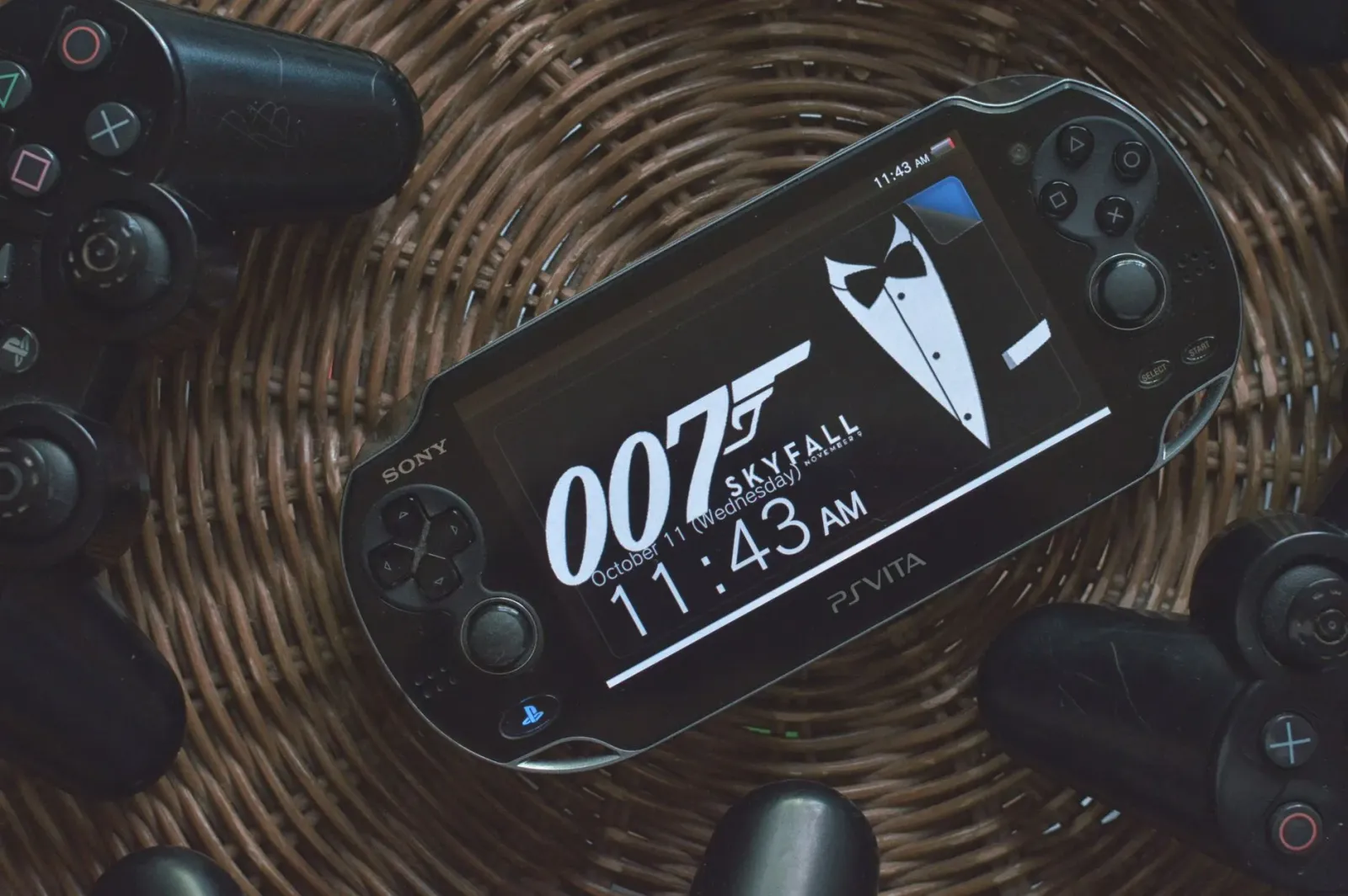 Imajen hatudu konsola PS Vita ho jogu dijitál iha ekrã, no disku PlayStation fiziku iha mesa, simboliza fin de era jogu fizik