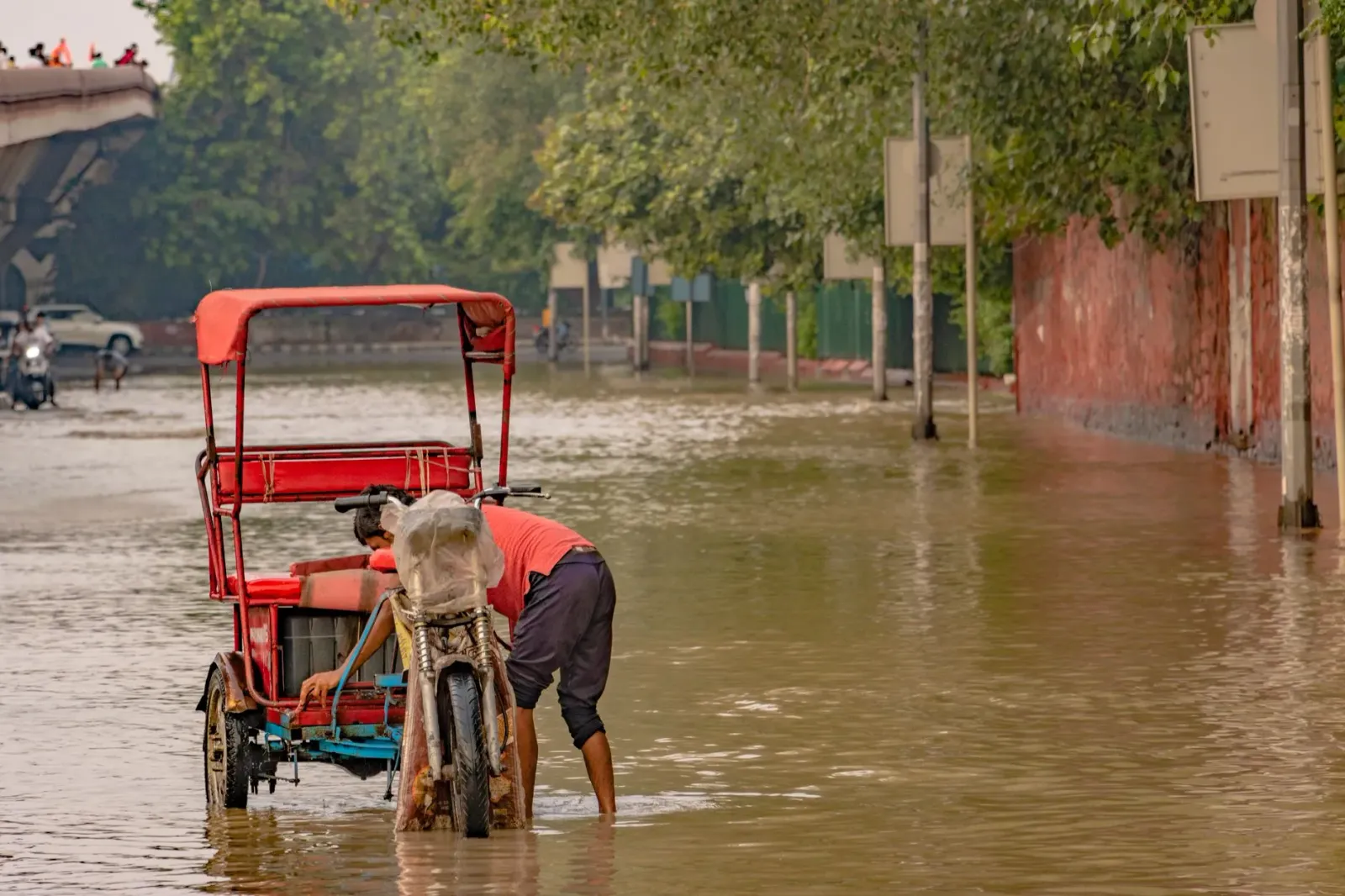 Ema iha Mumbai, India, haree bee inundasaun iha dalan durante udan boot monsoom, ho karreta sai subar hela