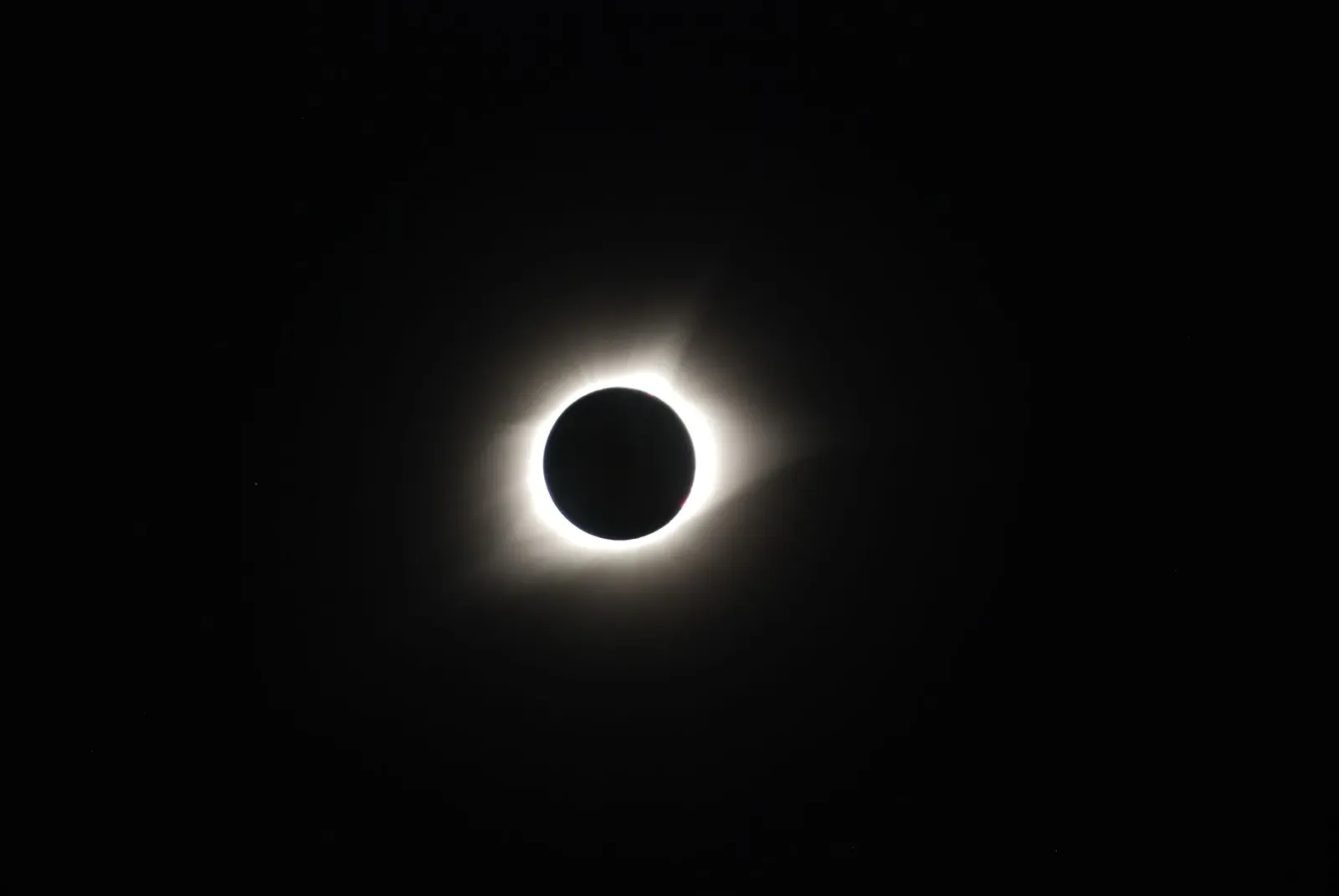Fotografia husi Lua hatudu koroa solar no rai iha distánsia, simboliza ligasaun entre sains espasu no etika