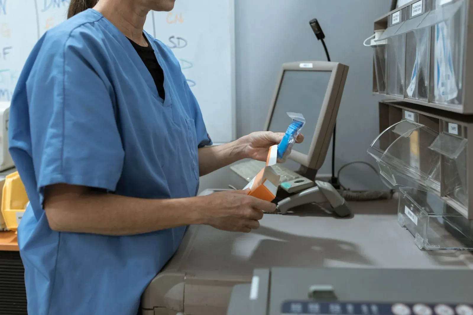Imajen ida hatudu farmasia iha hospital ho medikamentu sira iha prateleira, simboliza polítika foun Medicare ne'ebé redus pro
