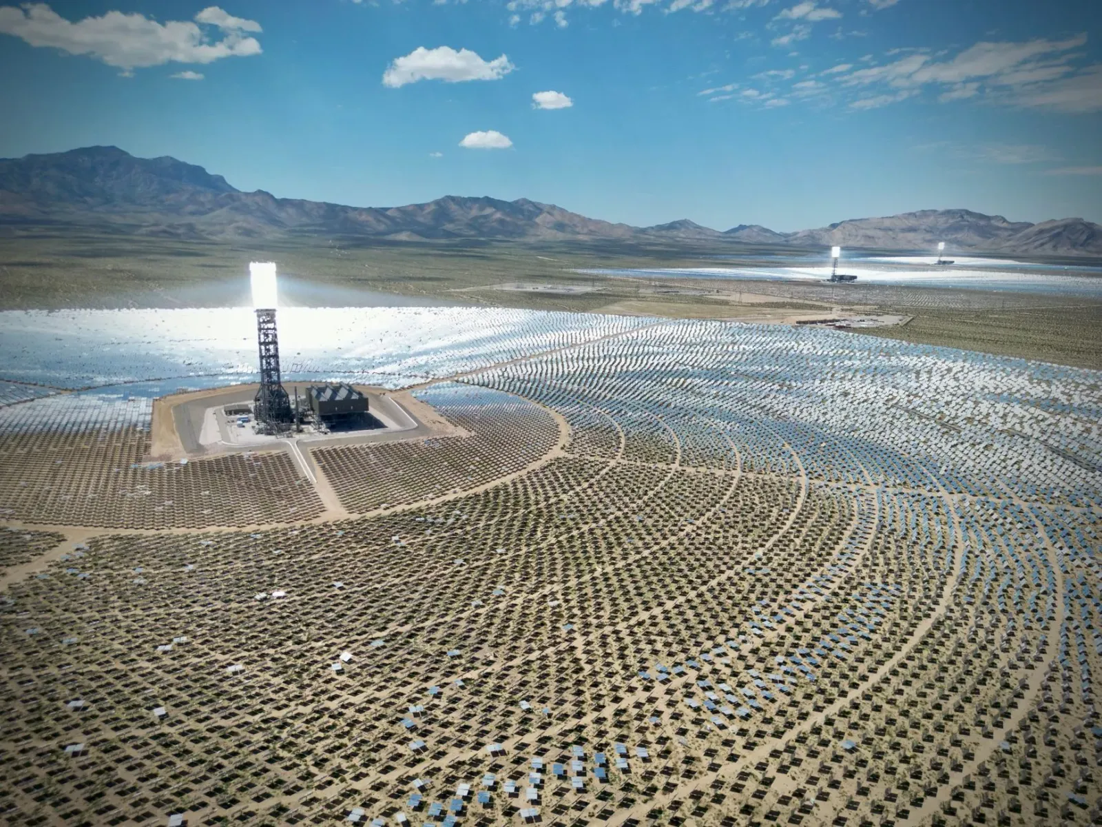 Imajen ida hatudu sientista sira ko'alia kona-ba transisaun enerjia iha workshop, ho mapa enerjia renovável iha latar, no ekr