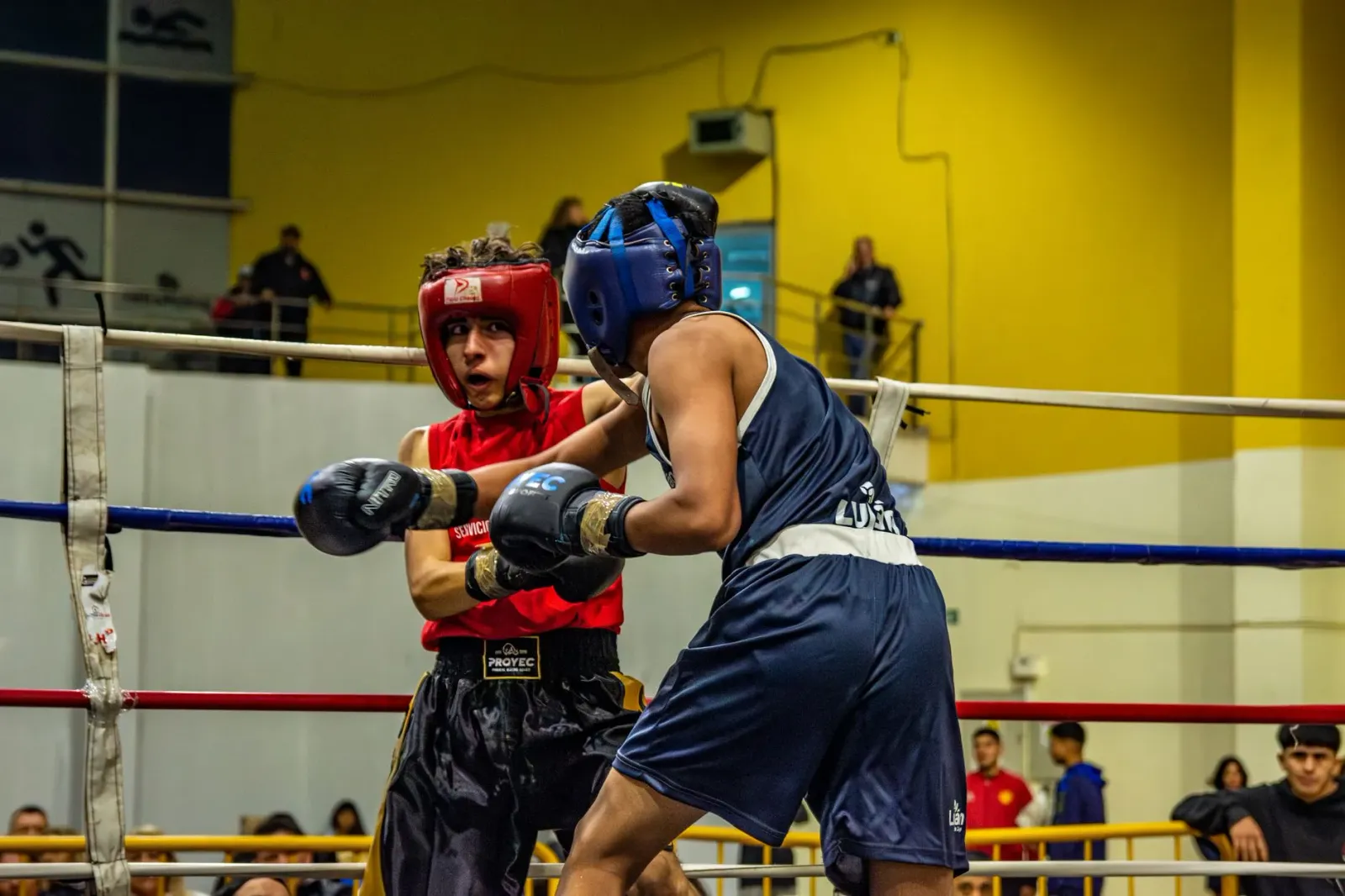 Atleta boksing iha arena iha momentu lutas, mostra foku no forsa, hanesan hanesan ema ne'ebé luta ba vida