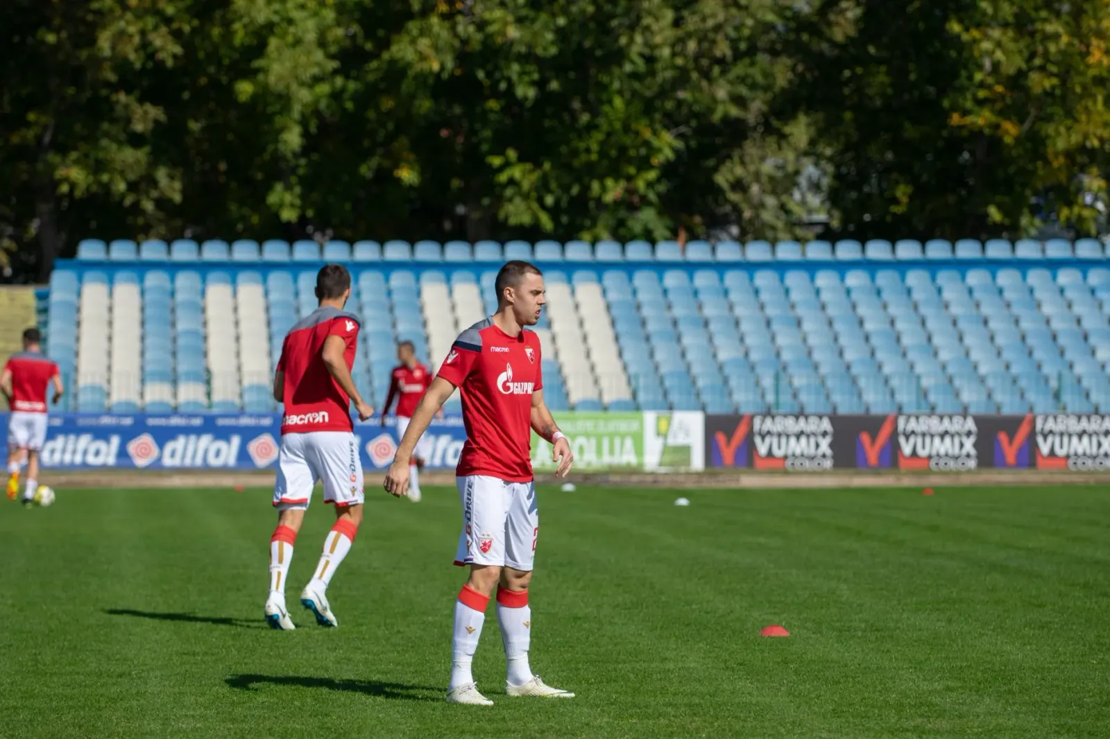 Imajen detalhadu kona-ba ekipa desportu iha estadion hodi prepara ba kompetisaun boot, ho luz ne'ebé halo atmosfera ofisiu.