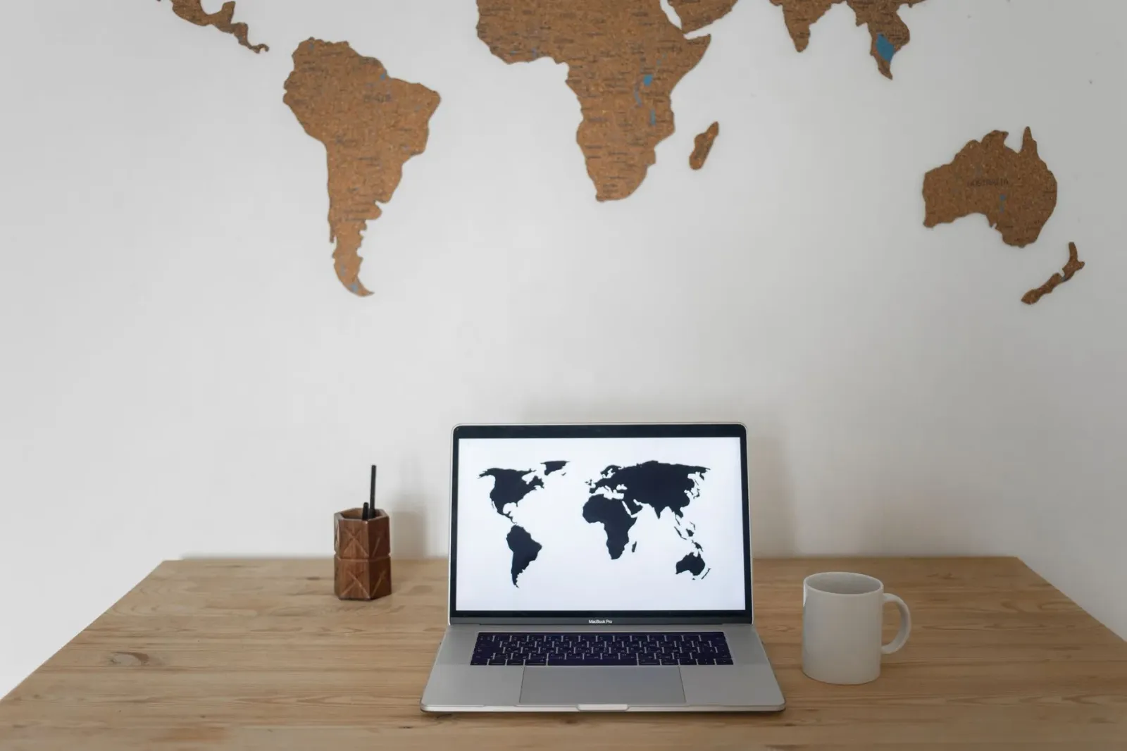 Imajen mostra ema sira iha escritóriu hanesan espertu negósiu ne'ebé analiza mapa mundu no laptop hanesan atu haree risco glo