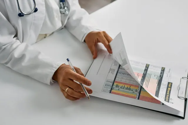 Doutór ida tau matan ba rekórdu mediku iha komputadór, ho tela AI copilot hatudu insight saúde, iha ospitál modernu