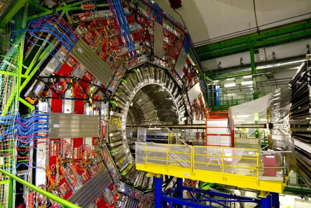 Imajen ida hatudu túnel iha rai okos CERN nian ho ekipamentu sientífiku boot no luz azul ne'ebé ilustra forsa invisível iha a