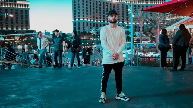 Imajen ida ne'ebé kombina elementu tolu: letreiru Caesar's Palace iha Las Vegas, ator Bollywood Rajeev Verma ho sorriso simpl