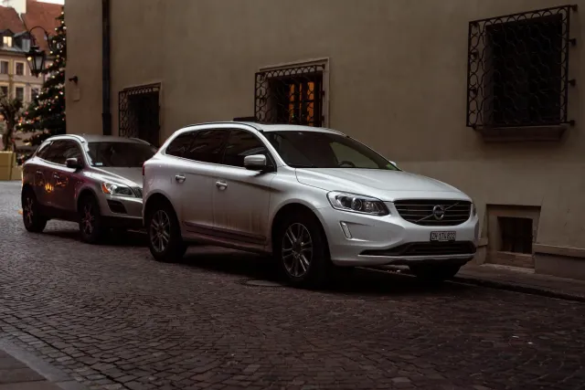 Imajen ida hatudu karru Volvo EX60 modernu iha kór azul metáliku, ho luz naroman hosi loron tuur, reprezenta inovasaun no est
