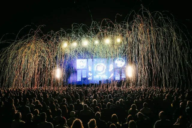 Vista husi eventu Android Show 2026 iha Google I/O ho ema barak tuur iha audiénsia no tela boöt hatudu logu Android
