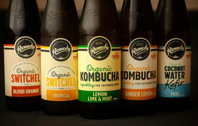 Imajen hatudu bebida fermentadu hanesan kefir no kombucha iha kopu kristal, ho kale no limão, ne'ebé reprezenta saúde tripa n