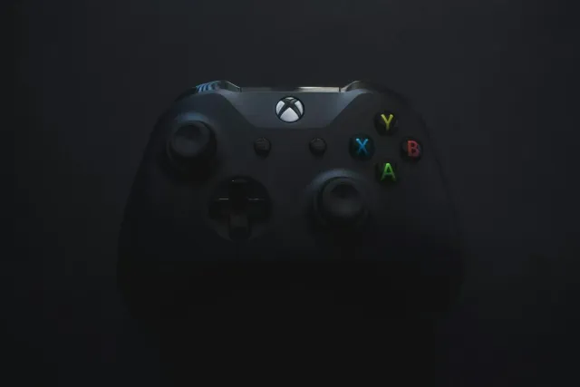Imajen ida hatudu kontroladór Xbox ho logo Gears of War no fundu neon, hodi ilustra ekskluzividade jogu ba plataforma Microso