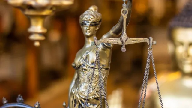 Imajen ilustrativu kona-ba balansa justisa ho edifísiu governu Punjab iha fundu, simboliza meritokrasia