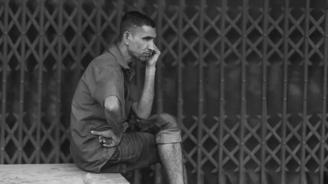 Ema ida tuur iha meja, hanoin kona-ba integridade no resiliénsia, ho notísia sira iha komputador