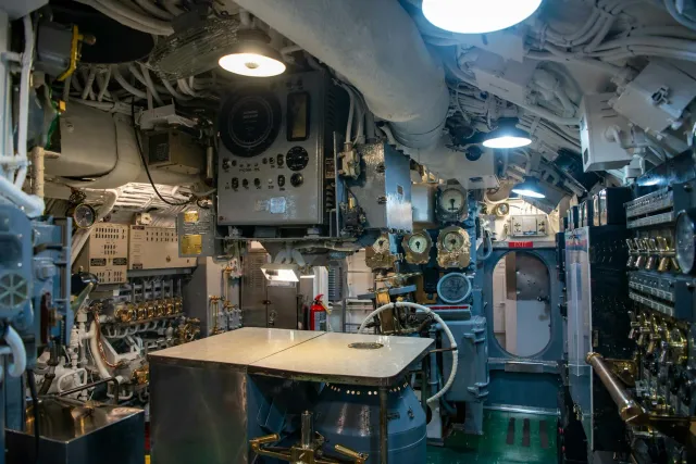 Drone submarinu boot ida iha tasi laran, ho luz azul no kabu komunikasaun iha kotuk, hanesan simbolu ba teknolojia seguransa 
