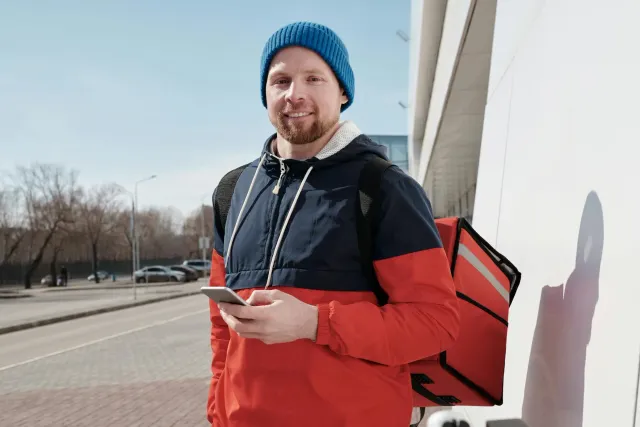 Traballadór gig ida uza smartphone iha dalan, ho sinal dijital no ikun eShram portal iha kotuk, hatudu prosesu rejistu trabal