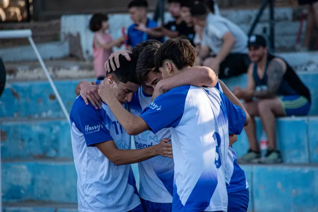 Imajen hatudu atleta mane na'in rua iha kampu desportu, sira haksoit no sorri, hatudu amizade forte no vulnerabilidade emosio