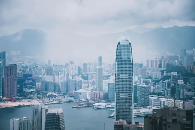 Imajen ida hatudu espasu servisu foun iha Hong Kong ne'ebé iha teknolojia AI, ho ema barak servisu iha meza no sala reuniaun 