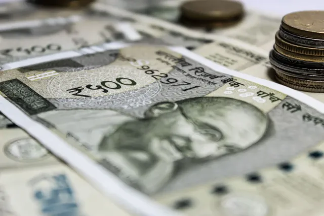 Imajen ida ne'ebé hatudu moeda rupia India no gráfiku merkadu sá iha kotuk, atu ilustra ekonomia India no mudansa resérva ban