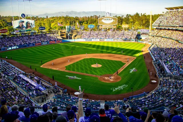 Imajen husi estadiu Los Angeles Dodgers ho jogadór baseball iha kampu, hatudu atmosfera jogu MLB nian.