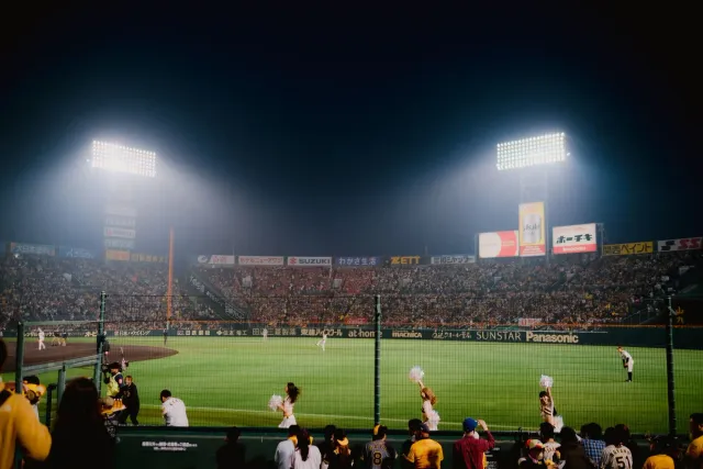 Imajen hatudu estadiu baseball ho fã barak sira tuur hela, hanesan simbolu ba atmosfera desportu ne'ebé enerjétiku no tensaun