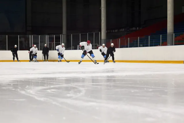 Jogadór Darnell Nurse husi Edmonton Oilers iha uma dezenvolve jogu, ho nia farda laranja no kapas, iha meiu partida ho arena 