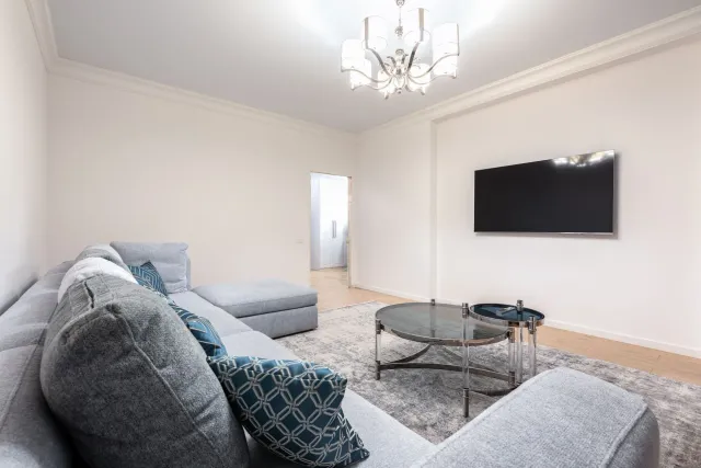 Imajen hatudu TV mount Perlegear iha uma ho LED luz nia iluminasaun, instalasaun ne'ebé di'ak iha parede betão, ho TV grande 