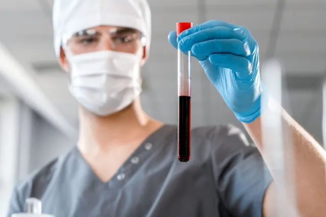 Imajen ida hatudu tubu rai teste kolesterol iha laboratóriu, ho korasaun no gráfiku risku iha fundu, ne'ebé ilustra konseitu 