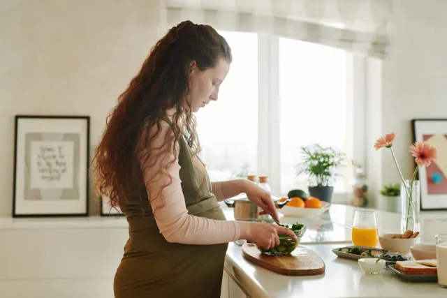 Feto isin-rua han hela fruta no modo fresku, simboliza saúde prenatal di'ak ba futuru labarik nian.